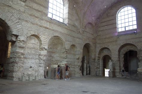 two people standing in the middle of an old building with stone arches ...