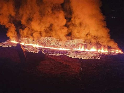 A volcano erupts in Iceland, sending lava flowing toward a nearby town ...