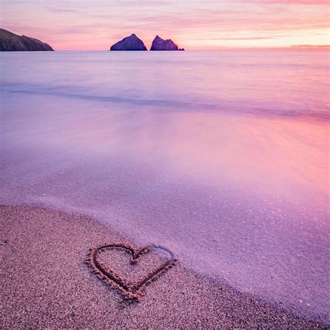 Premium Photo | Heart carved into sand on a seashore at sunset