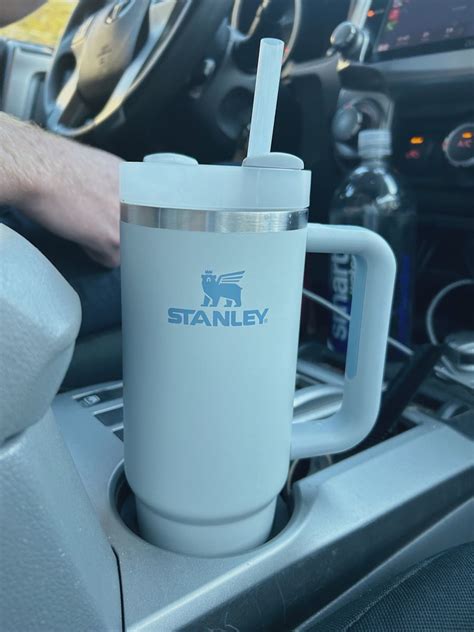 a person is holding a cup in their car