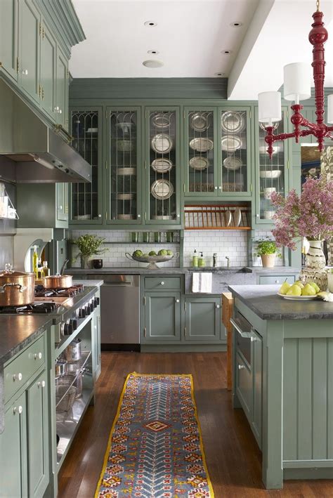 a kitchen filled with lots of green cabinets and counter top space next ...