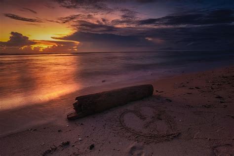 Premium Photo | A sunset with a heart drawn in the sand