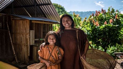 two women standing next to each other holding baskets