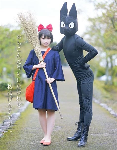 two women dressed up as black cats and holding brooms