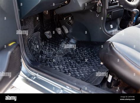 Dirty car floor mats of black rubber with gas pedals and brakes in the ...