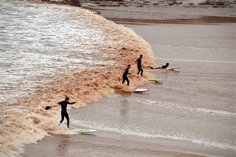 surfers are riding their surfboards on the waves in the water at the beach