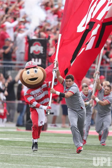 Photo: Ohio State Buckeyes mascot Brutus Buckeye and cheerleader run ...