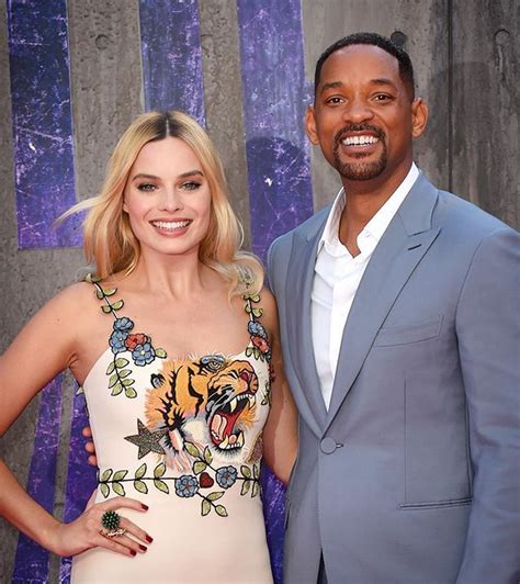 a man and woman standing next to each other on the red carpet at an event