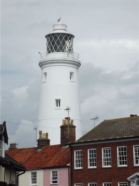 a white light house sitting on top of a building next to other ...