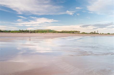 Uma praia com céu azul e nuvens | Foto Premium