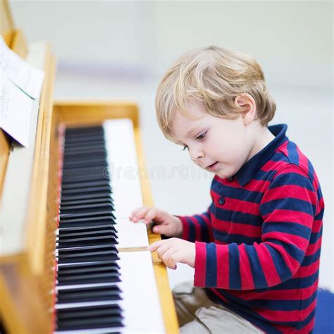 Two years old toddler boy playing piano, music schoool. Two years old ...