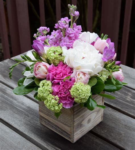 Flower arrangement in a wooden box, with peony, stock, tulips ...