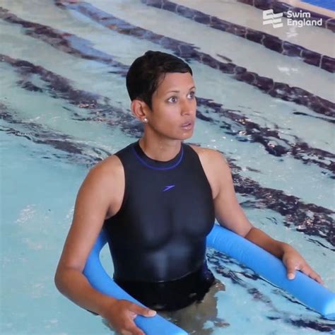 a man in a swimming suit holding a blue tube