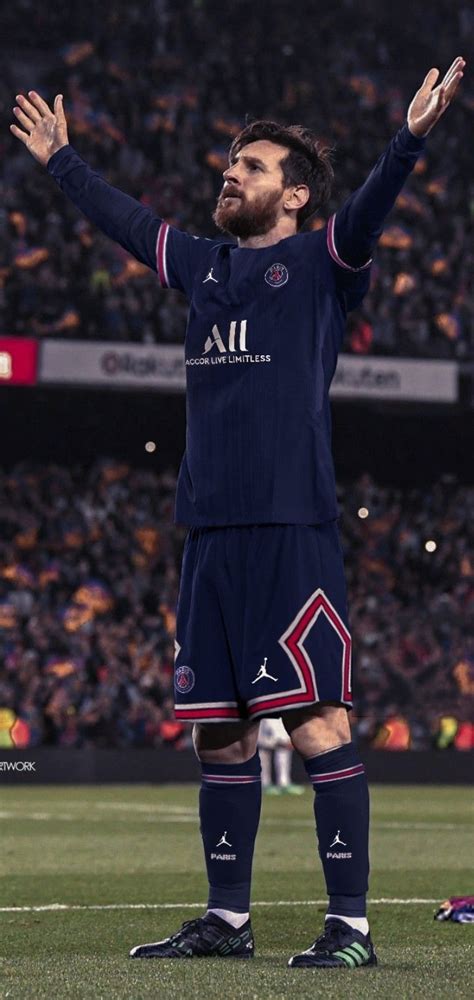 a man standing on top of a soccer field holding his hands up in the air