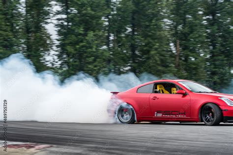 Fotka „Red Drift Car / Race car drifting around corner very fast with ...