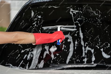 Premium Photo | Hand using squeegee to washing windshield of car