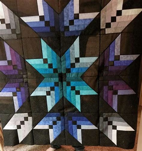 a quilt made to look like a star with blue and purple squares on it ...