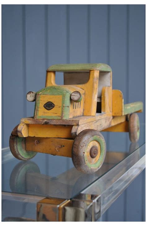 a wooden toy truck sitting on top of a glass shelf next to a blue wall