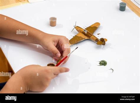 Painting plastic model kit of ww2 aircraft plane at home. Boy hobby and ...