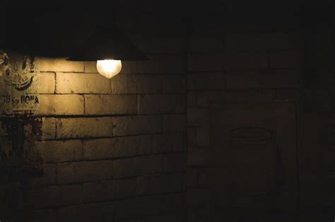 Premium Photo | Dim light lamp on the brick wall for dark rustic background