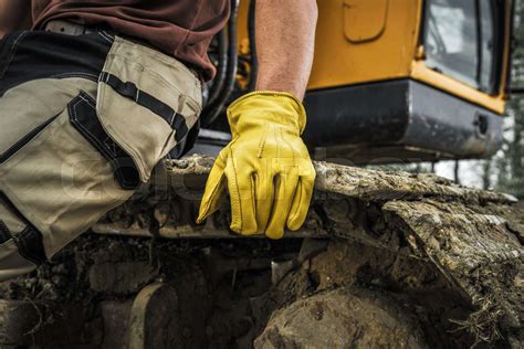 Bulldozer Operator Resting on a Caterpillar Track | Stock image | Colourbox