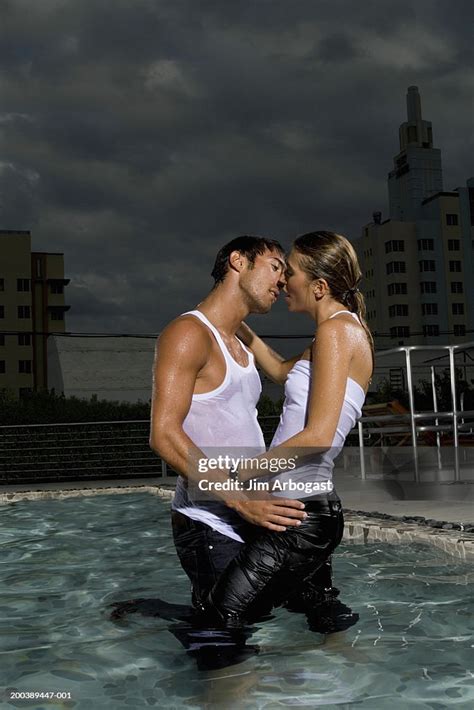 Young Man And Woman Embracing And Kissing In Pool Dusk Side View High ...