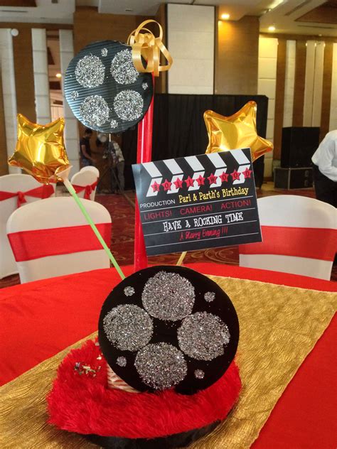 Bollywood theme party - table centrepiece with discs and clapboard and ...