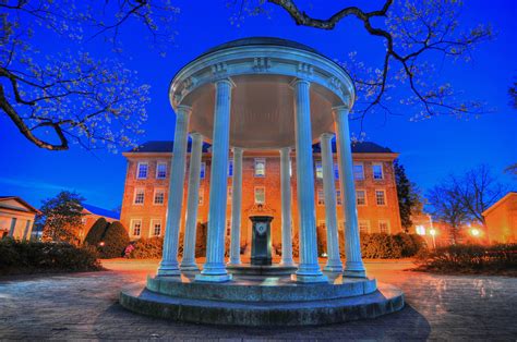 a gazebo lit up at night in front of a large building with columns and ...