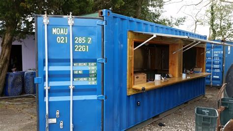 a blue shipping container sitting on the side of a road