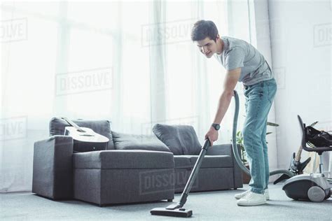 Teenager vacuuming floor in living room with vacuum cleaner - Stock ...