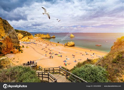 Wooden walkway to famous Praia Dona Ana beach with turquoise sea ...