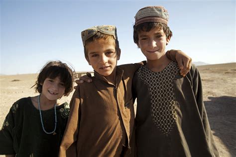 Afghan children pose for a photograph while watching U.S. Marines and ...