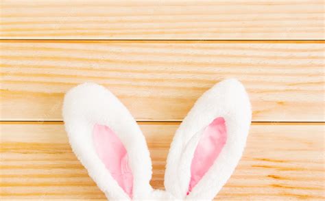 Premium Photo | White bunny ears on a light wooden background ...