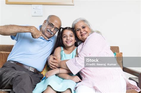 Portrait Of Indian Grandparents Hug Grandchild And Looking Towards The ...