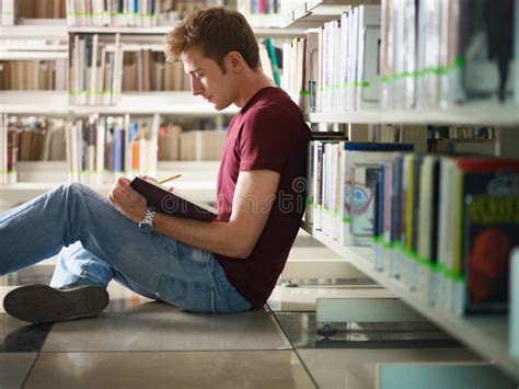 Young Man Doing Homework and Studying in College Library Stock Photo ...