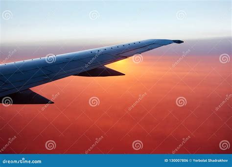 Airplane Wing in Flight at Sunrise with Sky, Clouds on the Background ...