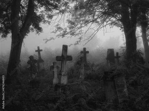 Dark spooky cemetery in the fog. Crosses and graves in the old ...