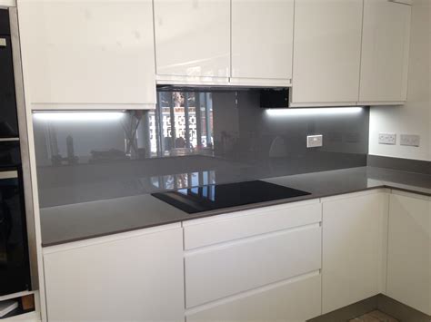 Painted glass splashback in grey, contrasting with the kitchen units ...