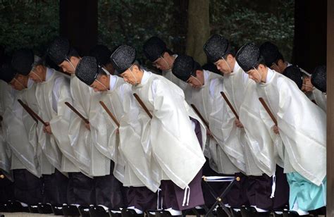 Japan Shinto priests bow during a ritual end-of-the-year purification ...