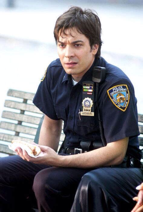 a police officer is sitting on a bench and holding food in his hand ...