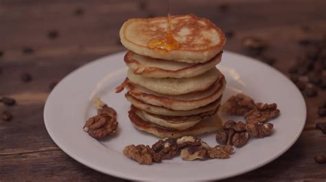 Pancakes with honey and nuts on a plate 10963959 Stock Video at Vecteezy