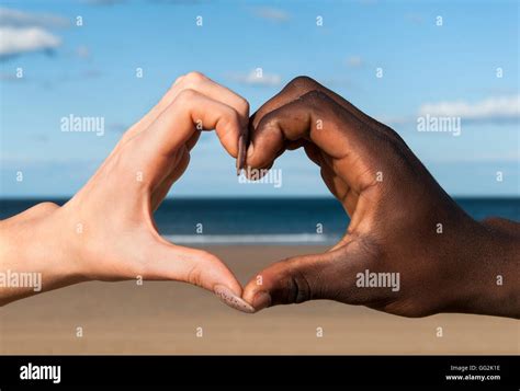 Heart hands Multicultural hands male and female in heart shape at beach ...