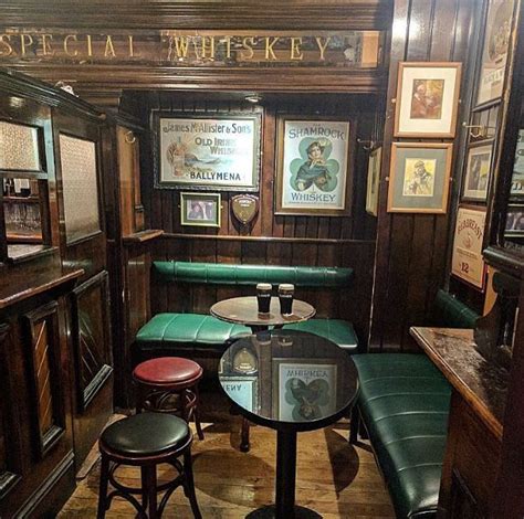 the inside of a restaurant with wooden walls and green leather booths ...