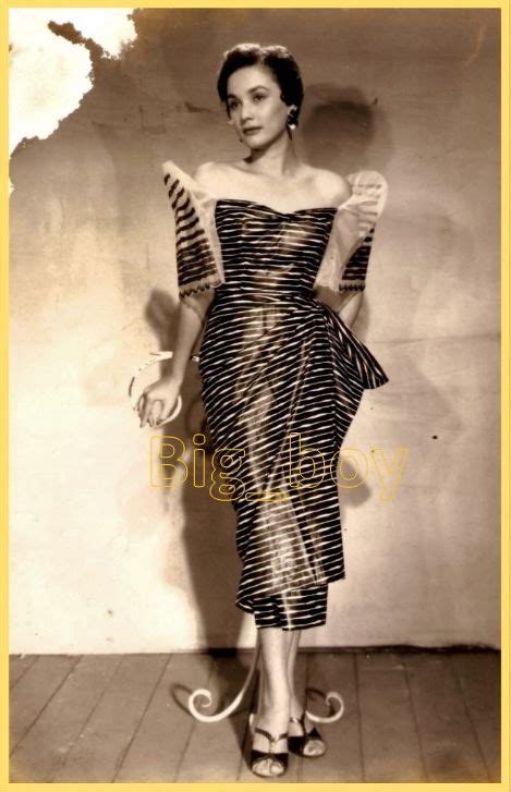 an old black and white photo of a woman wearing a dress with stripes on it