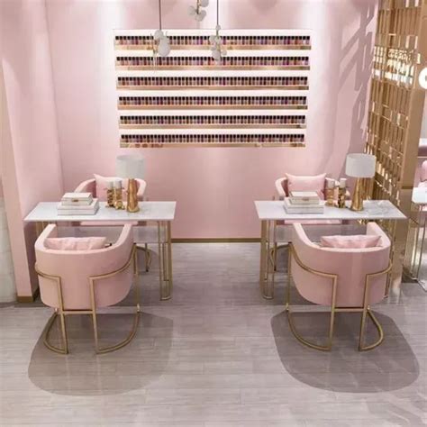 a nail salon with pink chairs and gold accents