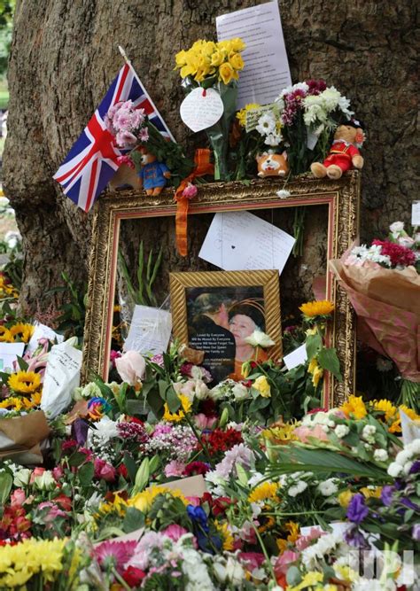 Photo: Members of the public lay flowers in remembrance for Her Majesty ...