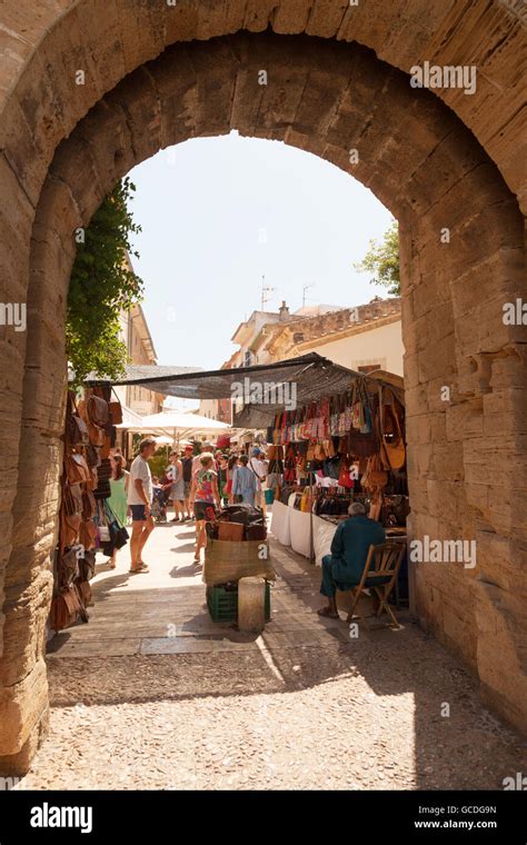 The market in Alcudia old town seen through an arch in the town walls ...