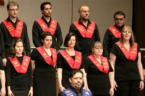 Group of People in Choir Uniforms with Red Sashes