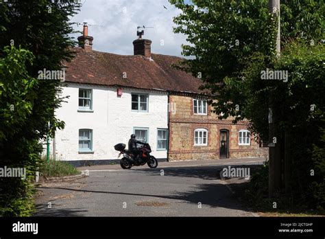 Rogate village in West Sussex, England, UK, with motorbike driving past ...