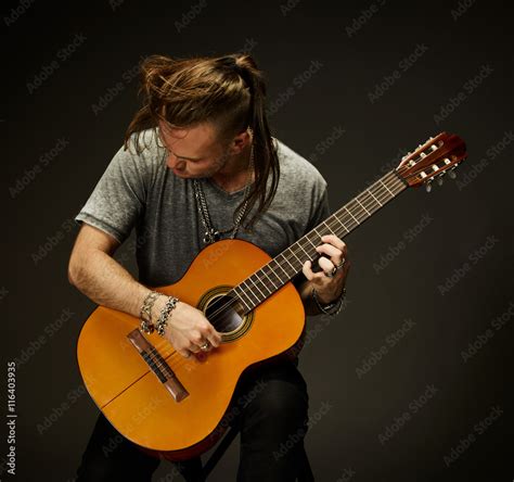 The guy playing an acoustic guitar. Stock Photo | Adobe Stock